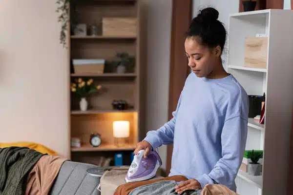 Femme repassant du linge à domicile dans un salon chaleureux et cosy